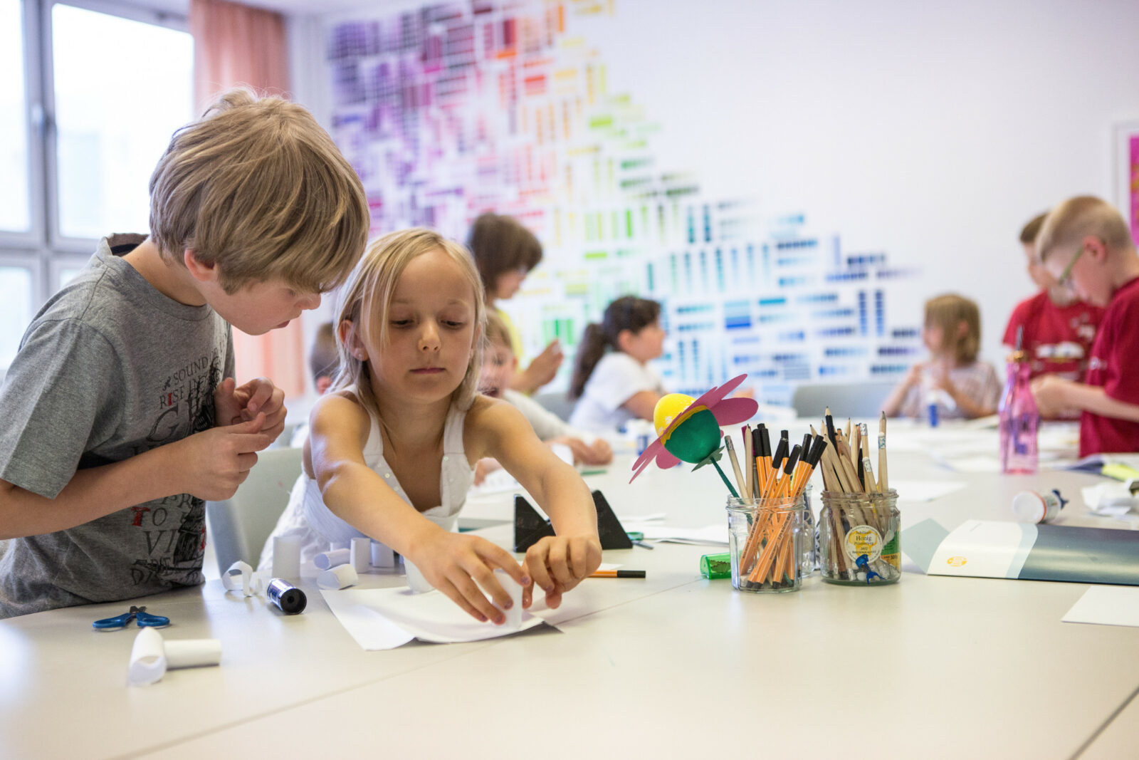 dreieins Innovative Pädagogik – dreieins Grundschule: Dargestellt sind Schüler und Schülerinnen in einem Klassenraum.